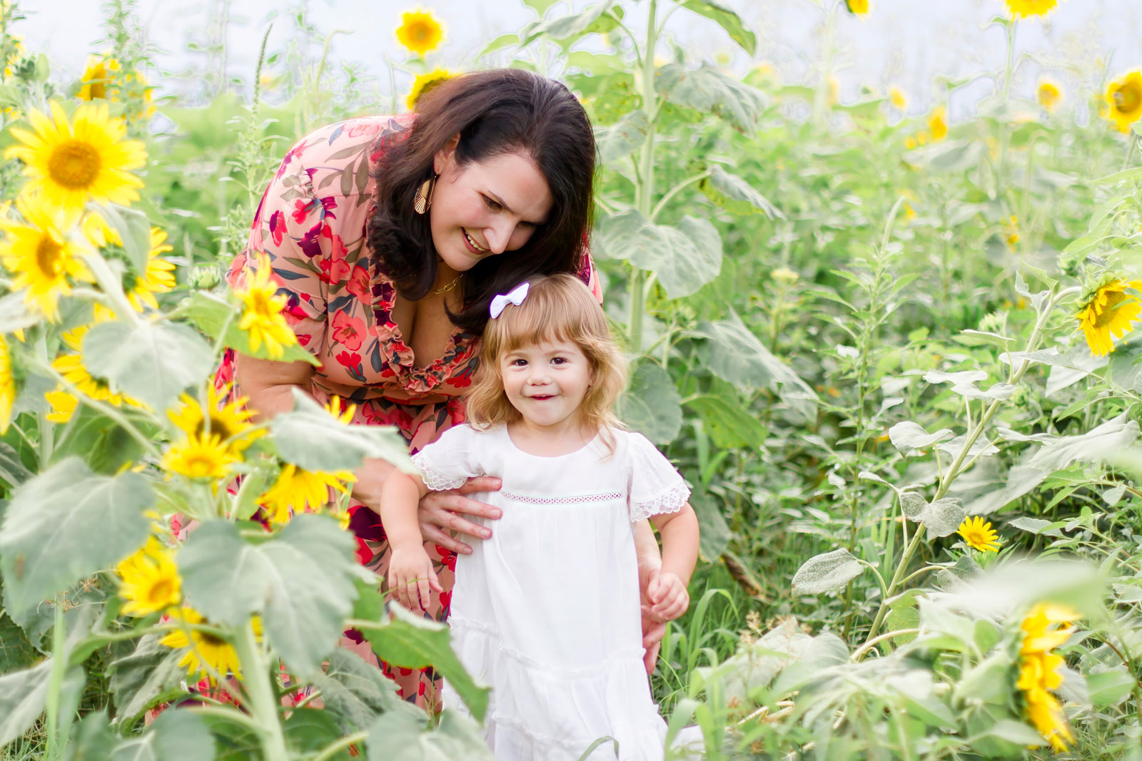 mom holding her little girl by the sunflowers at the sunflower field in Belcher, LA