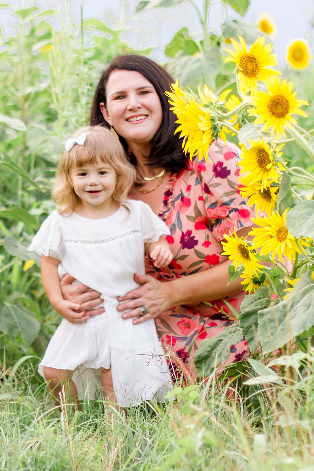 mom and daughter smiling by the sunflowers at the sunflower field in Belcher, LA