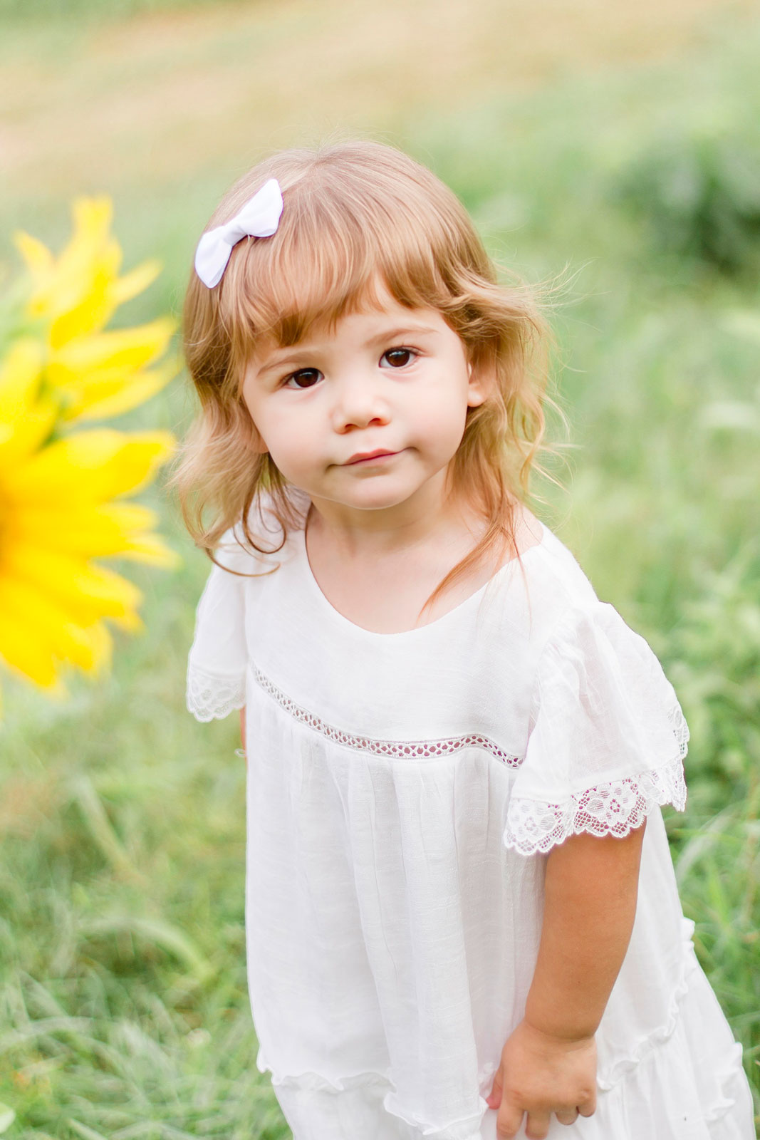 little girl stopped to pose next to the sunlowers at the sunflower field in Belcher, LA