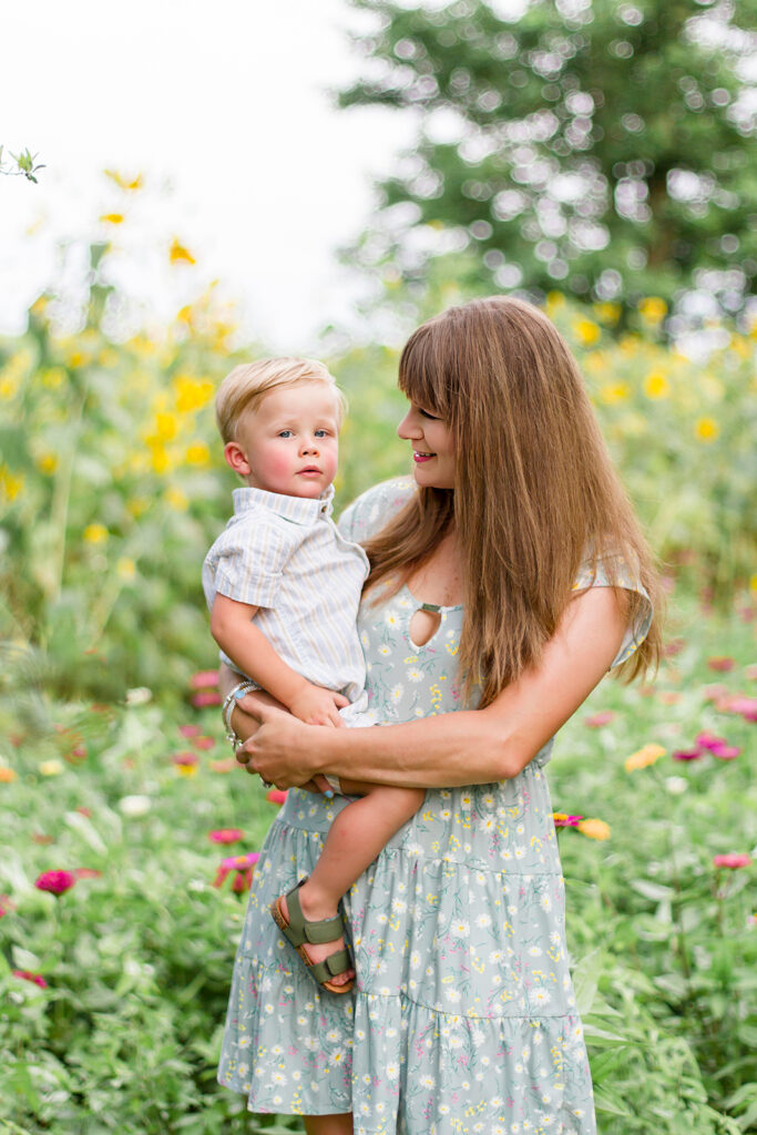 Mom holding her youngest child in the wildflower field in Belcher, LA