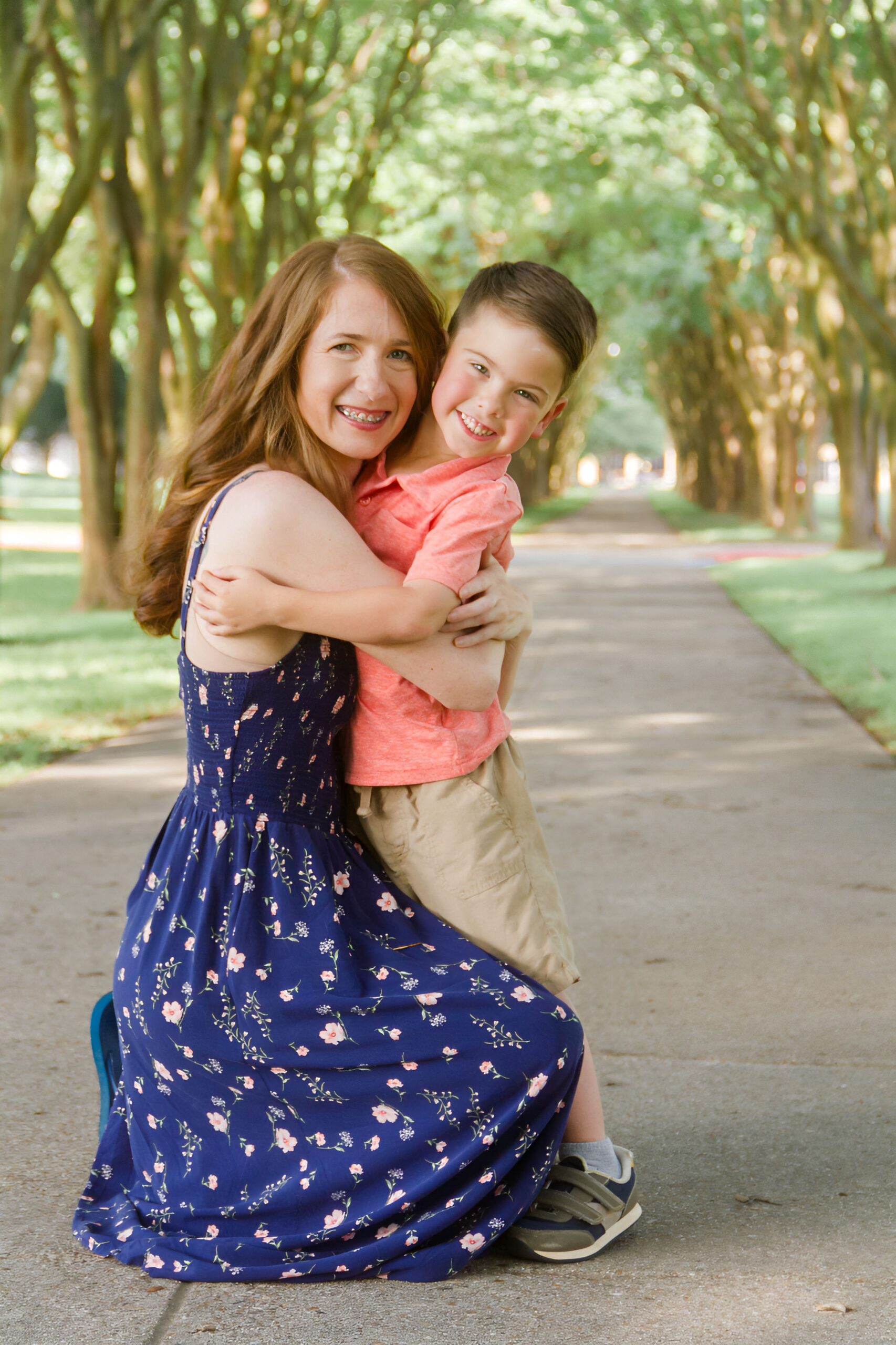 mom hugging her son on a pathway between trees outdoor for a family session in Shreveport LA