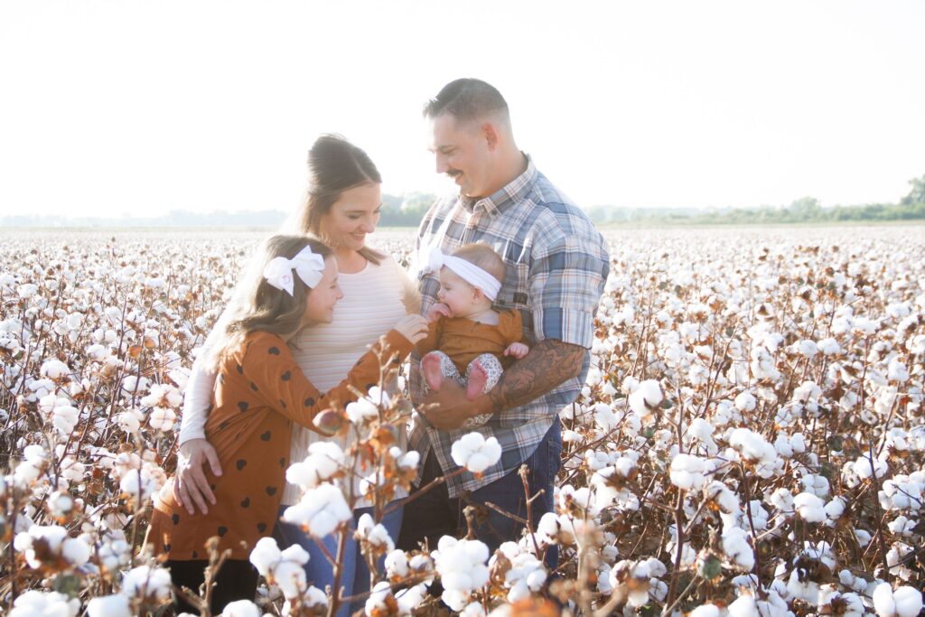 family of four hugging and playing at the cotton field in belcher, la