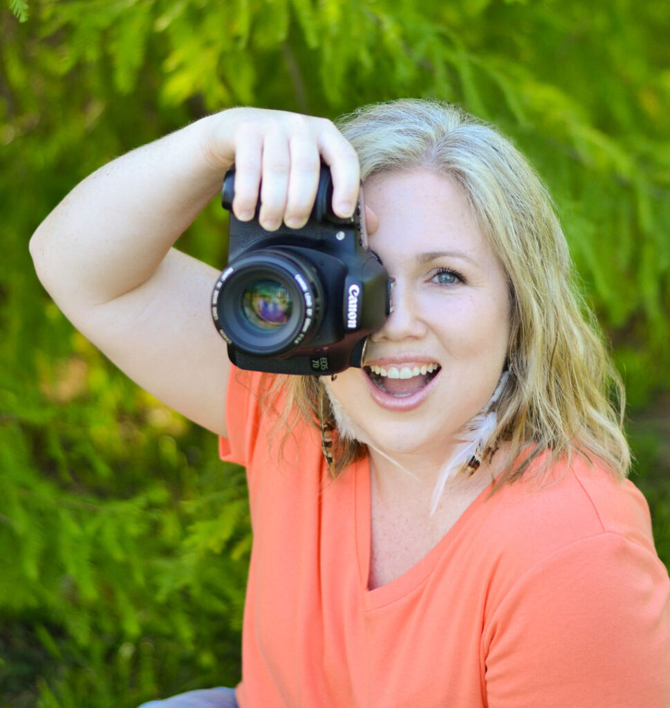 woman looking through the view finder of the canon camera smiling while in Benton, Louisiana