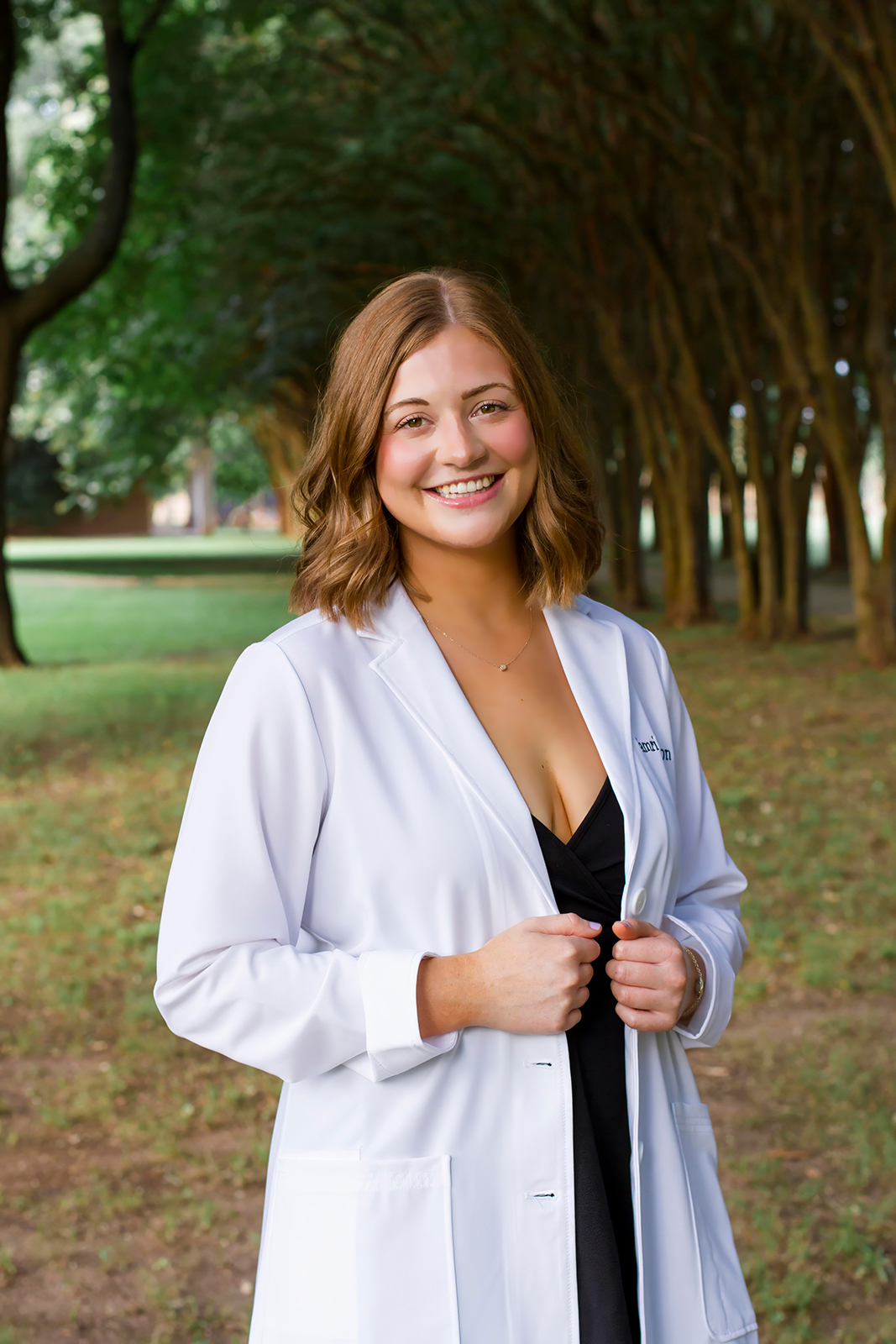 College grad med senior wearing white coat on LSUS campus Shreveport LA