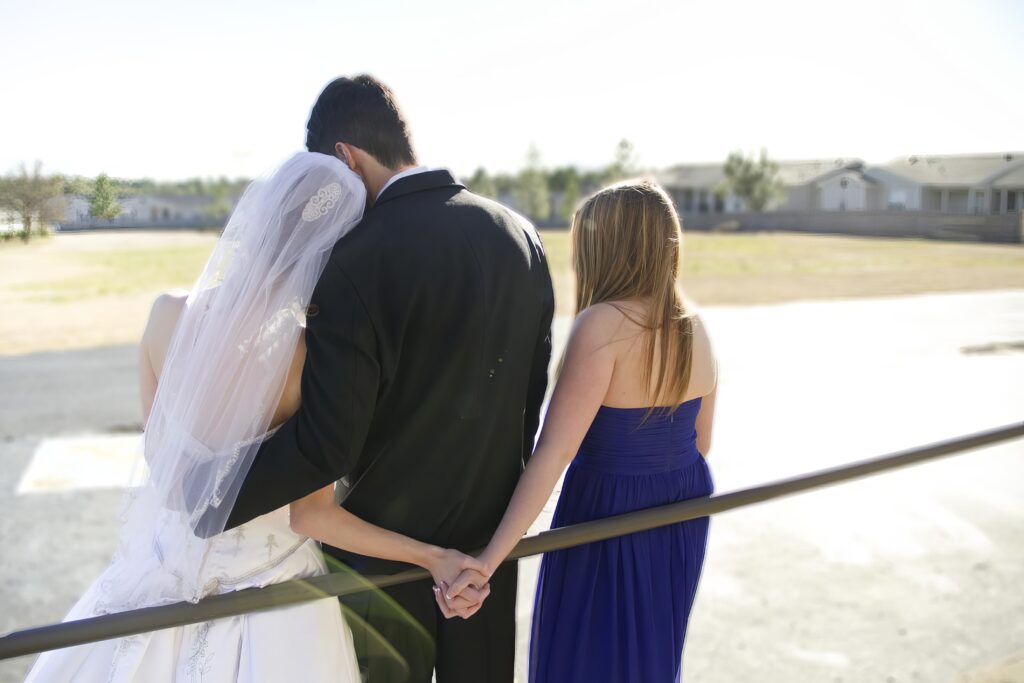 bride and groom cuddling while bride and maid of honor are holding hands in Shreveport, LA