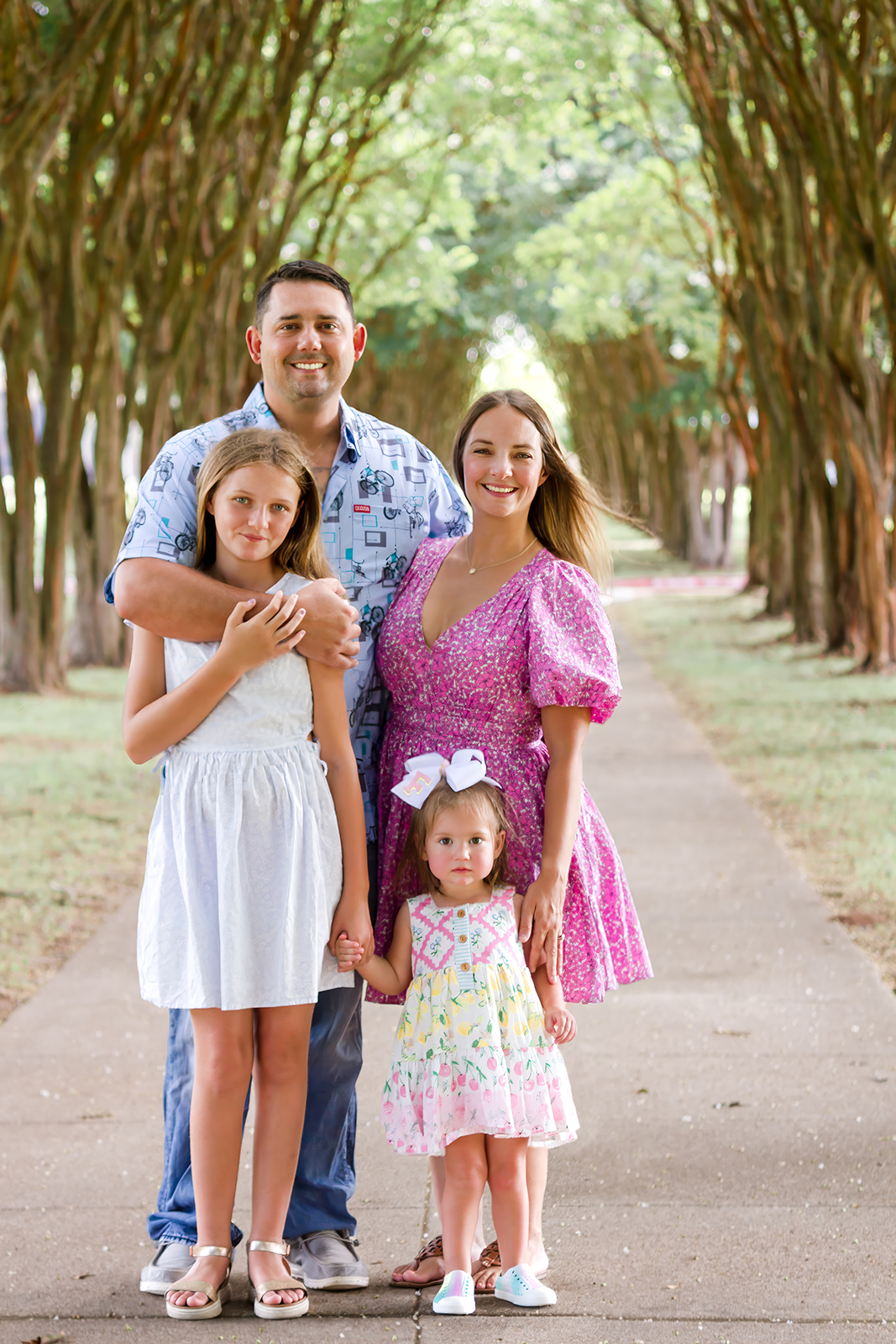 family of four smiling on a pathway on LSUS campus in Shreveport, LA