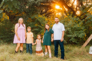 family standing outside in the green field during fall time in Shreveport, LA 