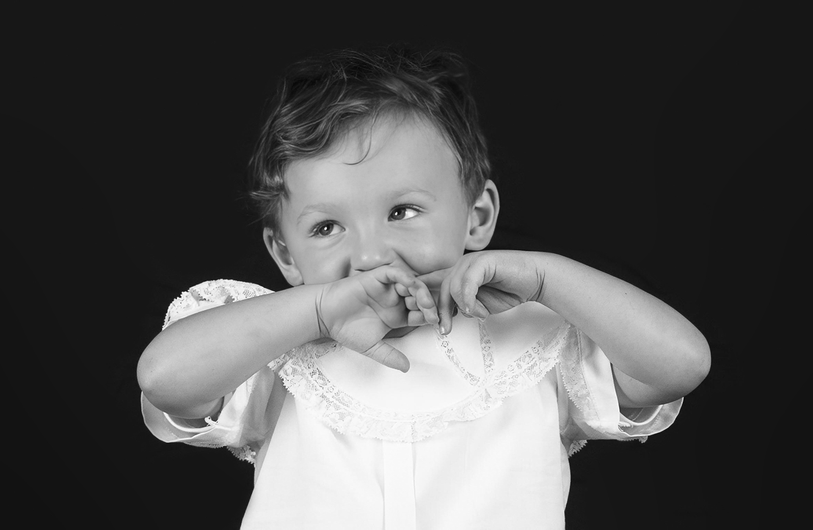 little boy toddler with his had on his mouth during personality portrait home studio session in bossier city, la