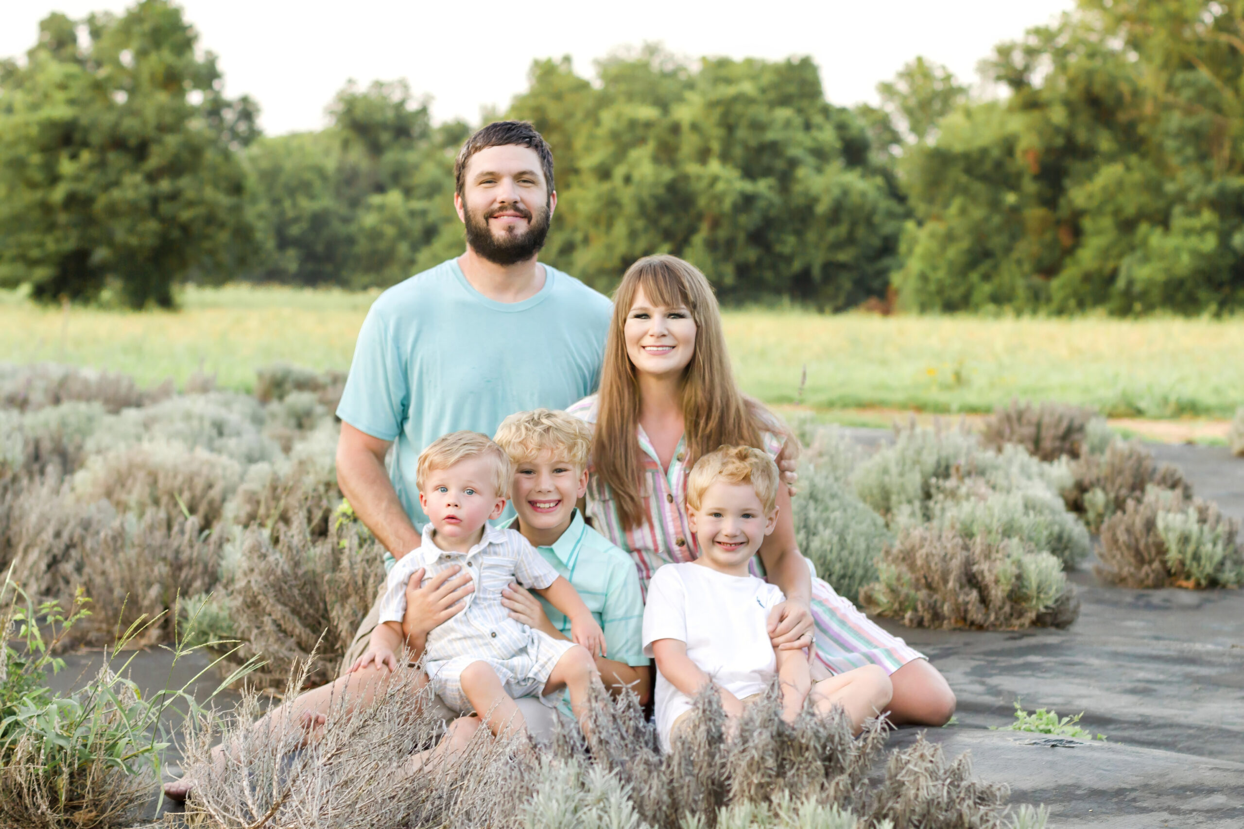 Family of five sitting and smiling at the Dixie Farm Lavender in Shreveport, LA