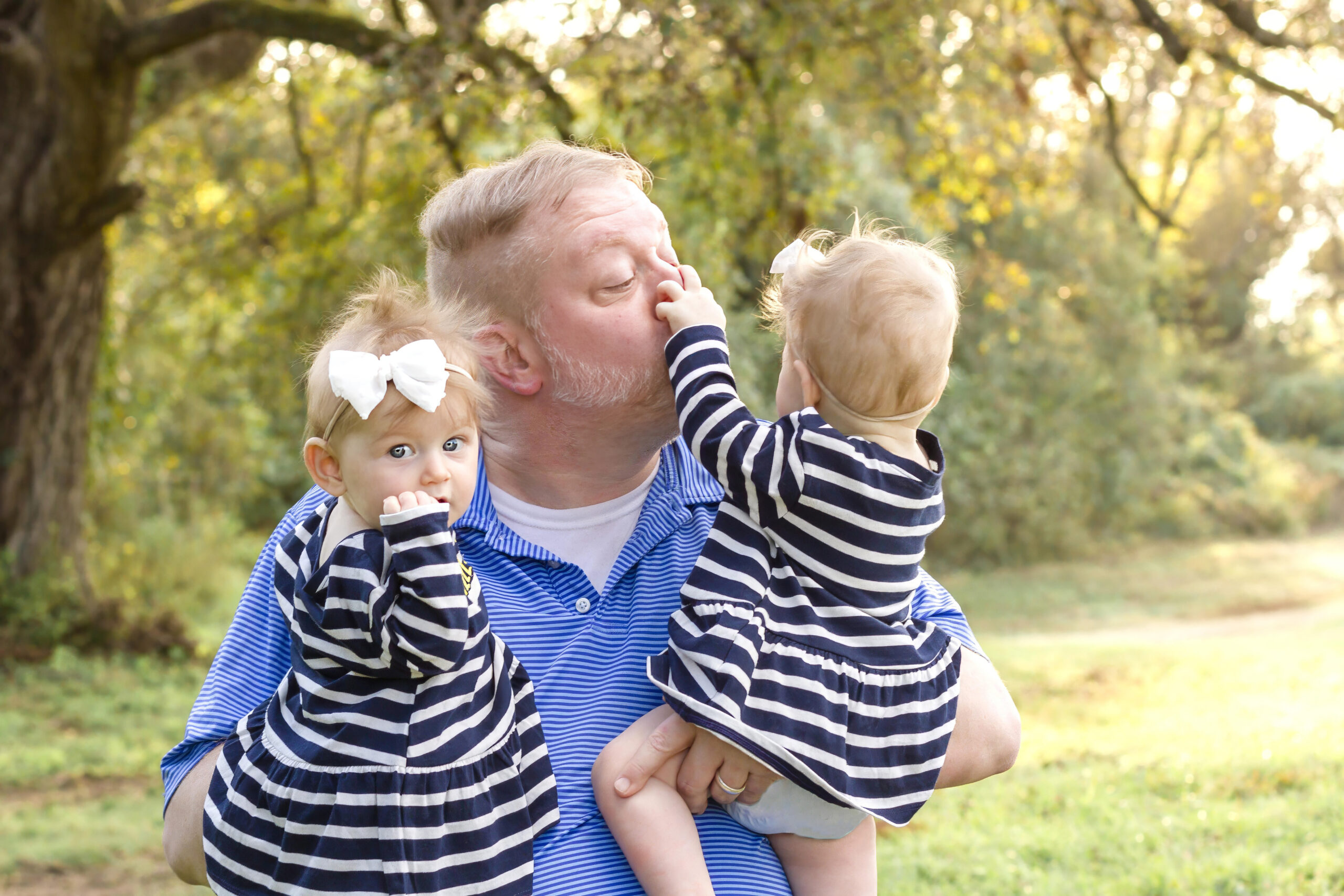 dad being silly while holding his twin baby girls in Bossier City, la at Red River Wildlife Refuge Center