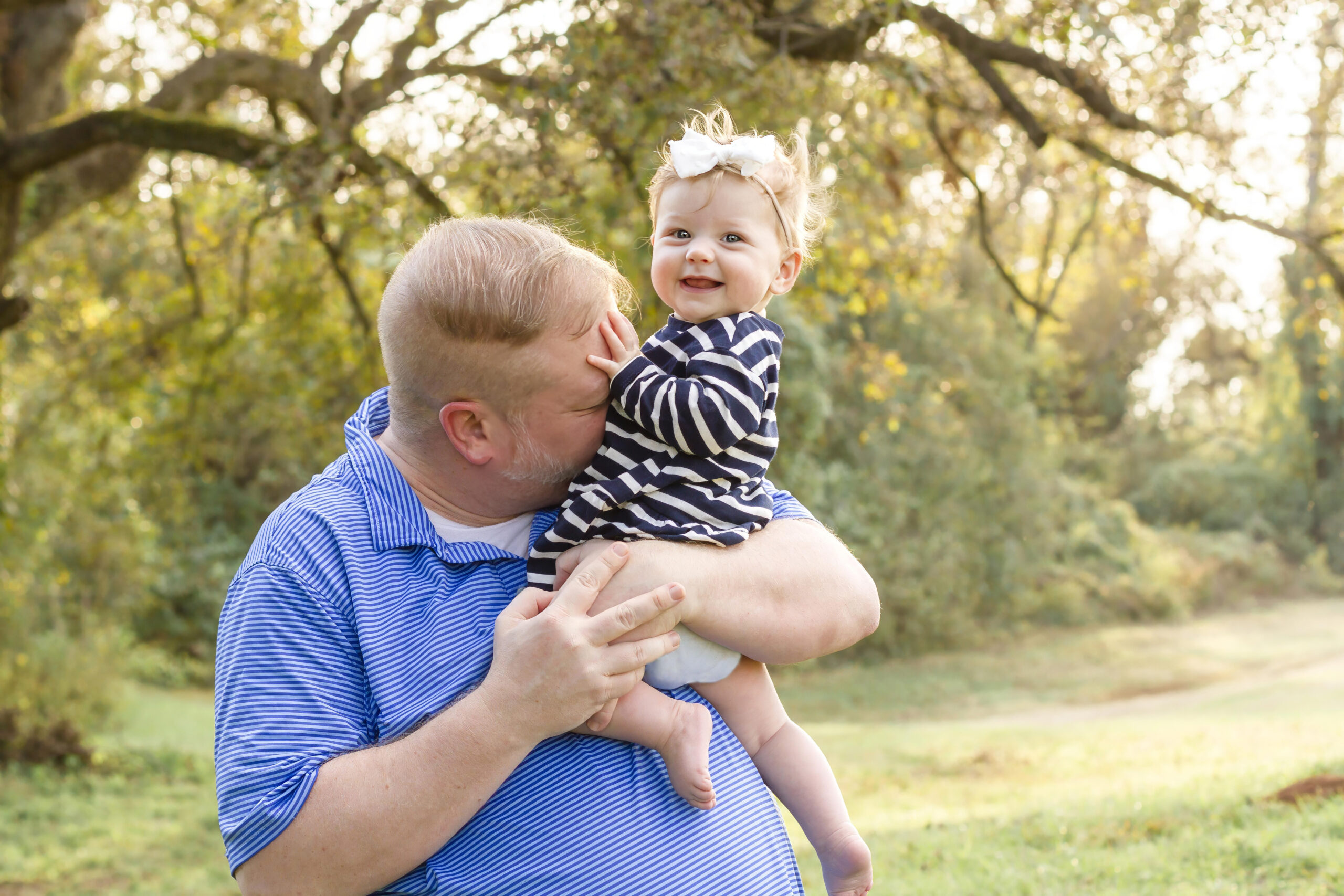 dad blowing raspberries on baby girl stomach in Bossier City, la at Red River Wildlife Refuge Center