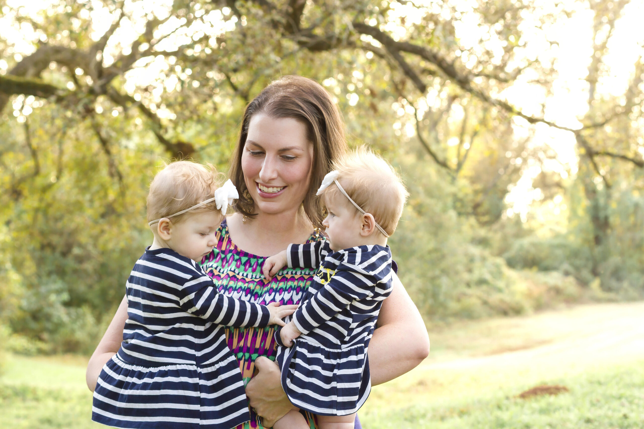 mom smiling while holding her twin baby girls in Bossier City, la at Red River Wildlife Refuge Center