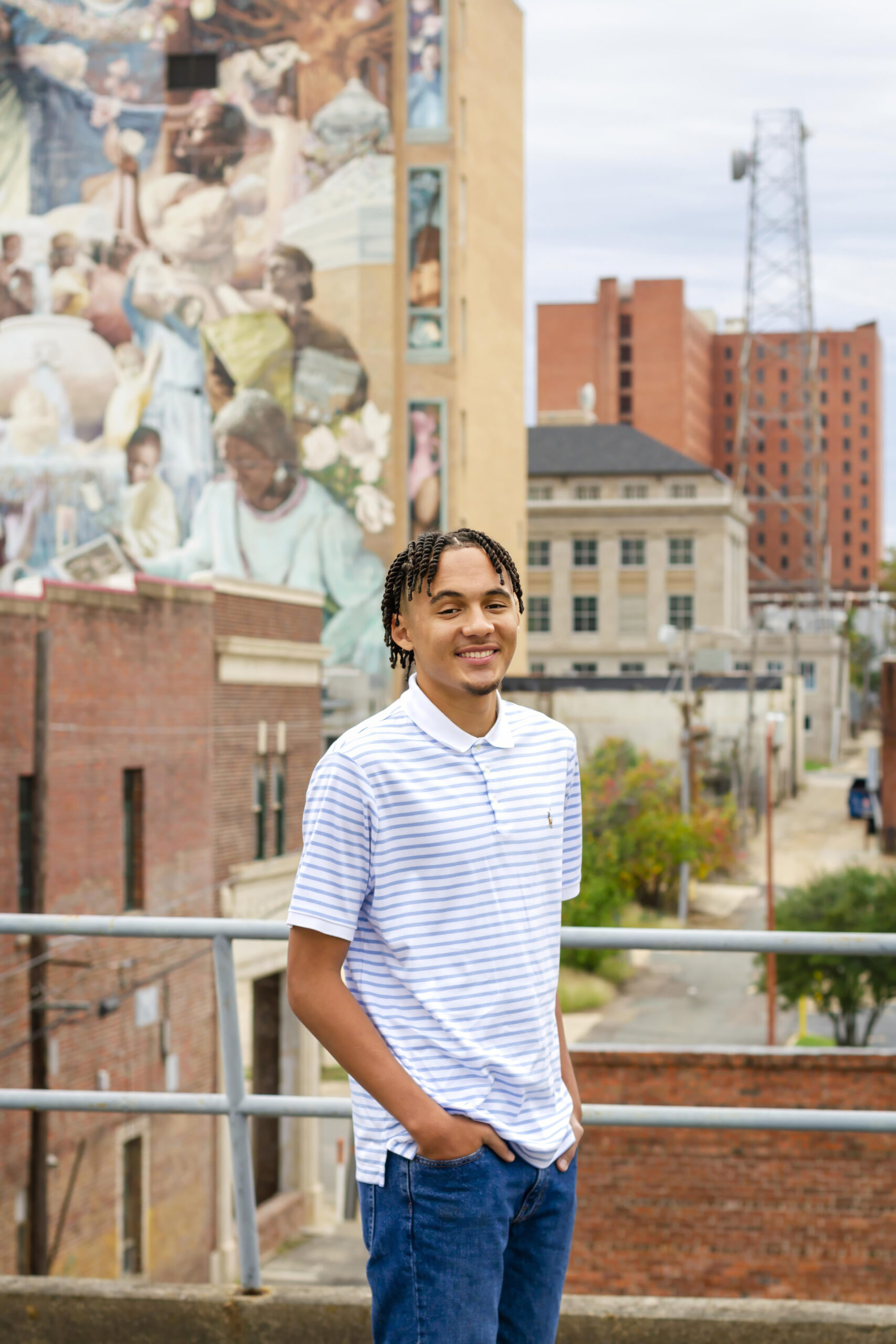 senior boy standing on an empty parking garage with a memorial behind him in downtown Shreveport, LA