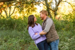 husband slightly dipping his wife as husband and wife look at each other in a grass field in Shreveport, LA 