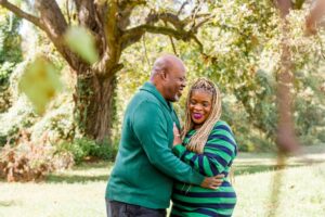 husband whispering in his wife's ear sweet things as she smiles at Red River Wildlife Refuge Center in Bossier City, LA