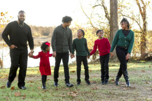 family playing bumping cars and bumping into each other while walking a straight line and holding hands at Red River Wildlife Refuge Center in Bossier City, LA