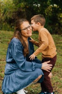 son whispering in his mom's ear while mom is kneeling at Red River Wildlife Refuge Center in Bossier City, LA