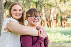 sister hugging her brother from behind at Lake Bistineau in Doyline, LA