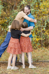 three kids giving their dad a huge in Haughton, LA