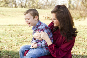 mom tickling her son while he sits on her lap at Red River Wildlife Refuge Center in Bossier City, LA