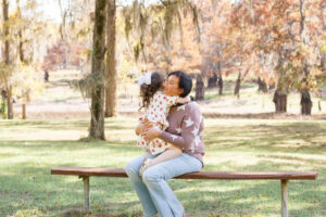 little girl giving her mom a hug while sitting on a bench at Lake Bistineau in Doyline, LA