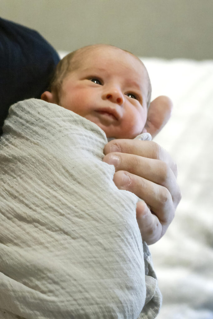 newborn baby boy being held by their dad in his house in Bossier City, LA